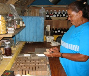 Hand wrapping the fresh bars of soap using recycled paper.